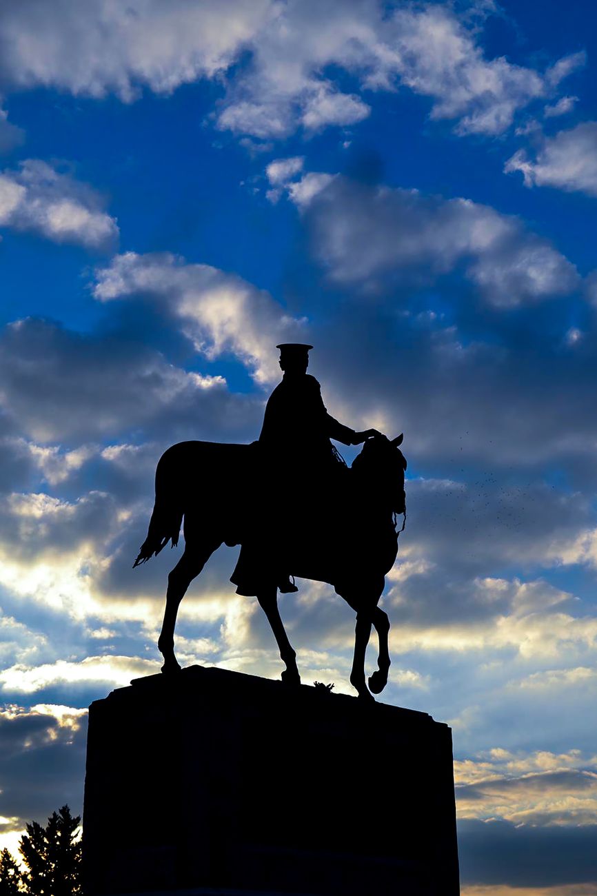 clouds over sculpture of man on horse
